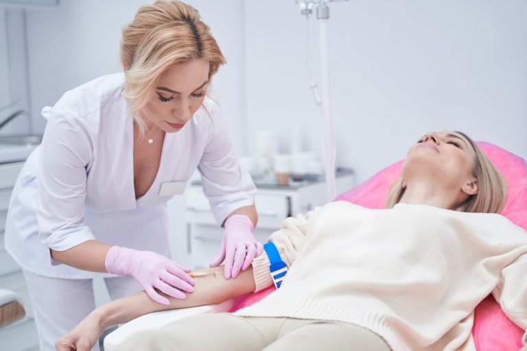 Focused physician preparing client for intravenous therapy