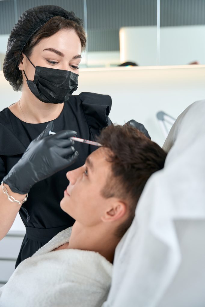 Male in beauty clinic getting hair injection procedures