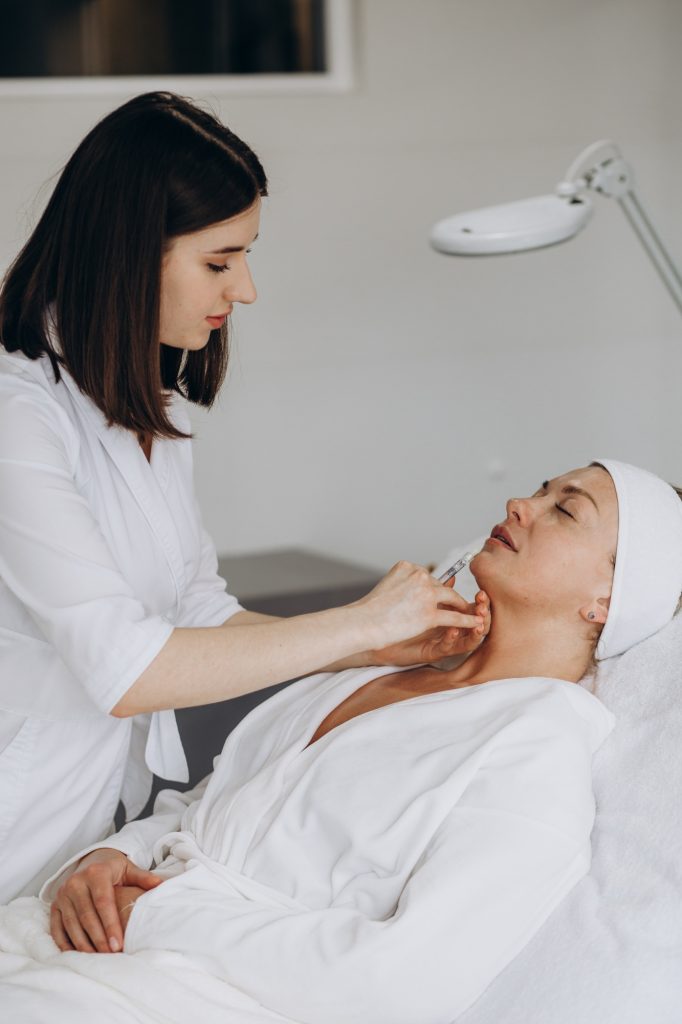 woman having lip injections, a prick of a syringe for the beauty lips. lip augmentation.