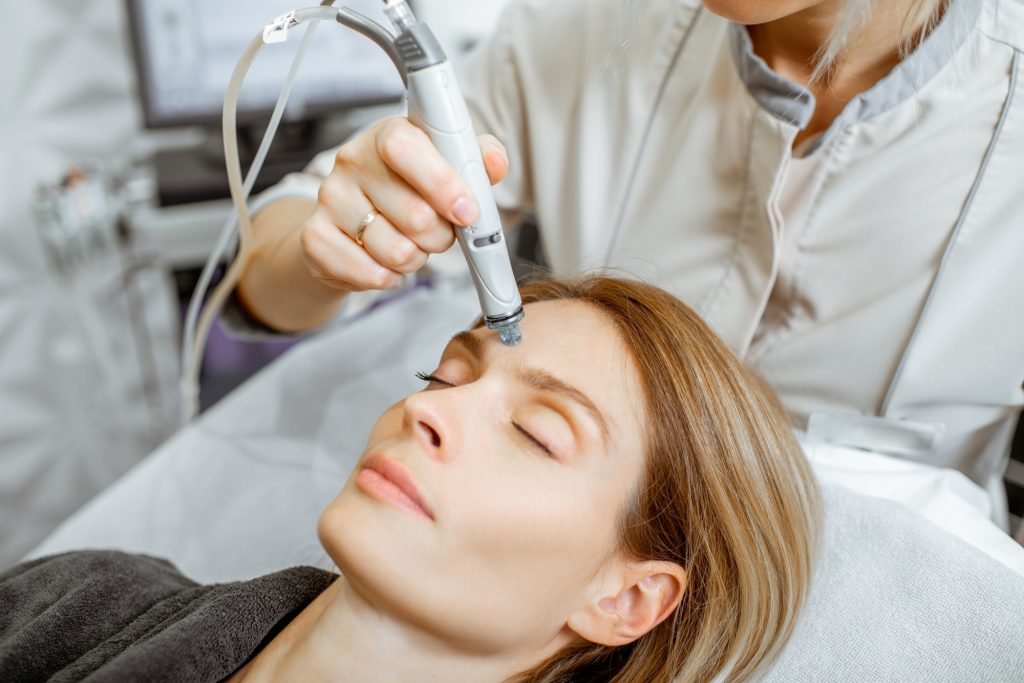 Woman making vacuum hydro peeling at the beauty salon