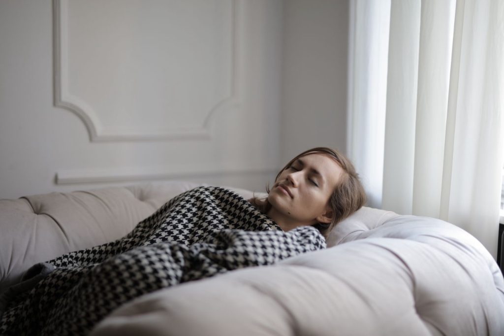 Mujer descansando en el sofá durante el postoperatorio